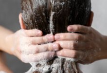 Young Woman Applying Anti Dandruff Product