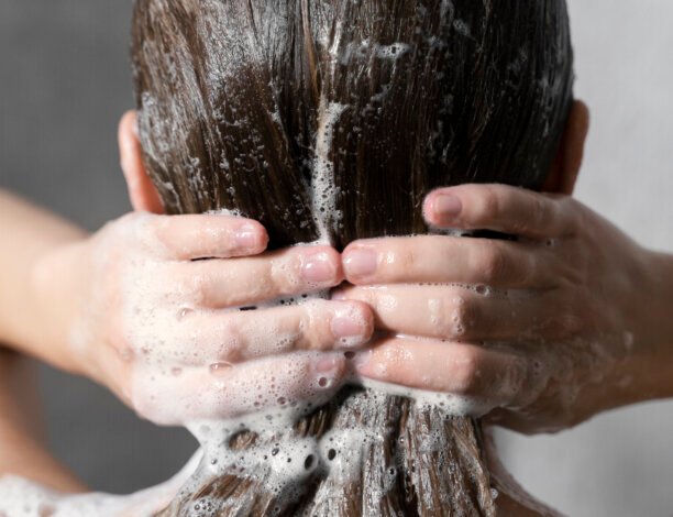 Young Woman Applying Anti Dandruff Product