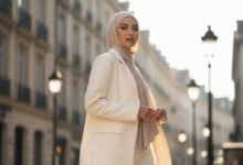 seorang wanita Muslim Indonesia modern (20-an) yang mewakili 'Effortless Elegance'. Dia mengenakan clean hijab pashmina jersey, dipadukan dengan oversized blazer krem dan celana kulot senada.